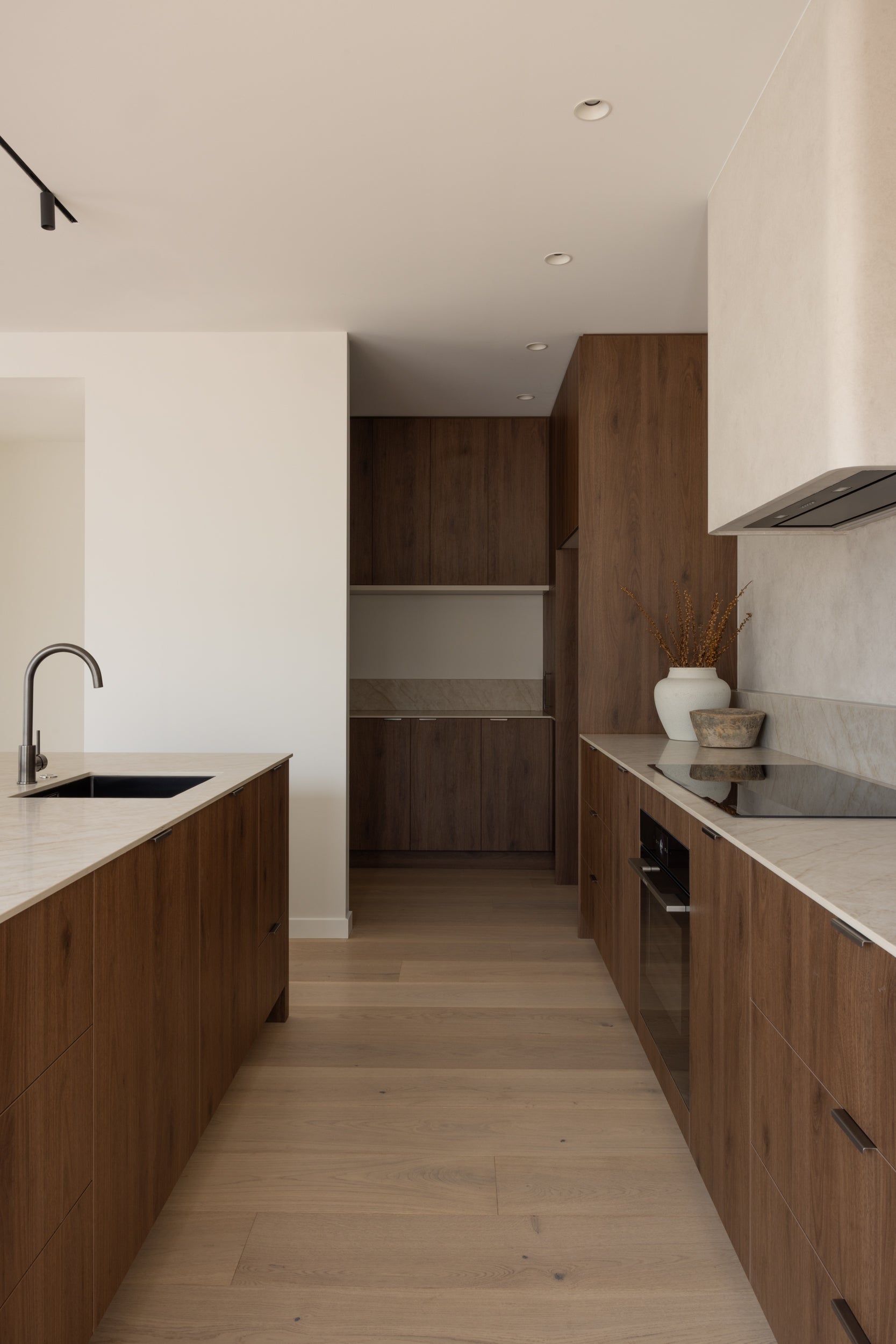 Blanc Oak flooring through a galley kitchen at Watford Street, Christchurch, pale boards contrasting with dark stained oak cabinetry and marble benchtops