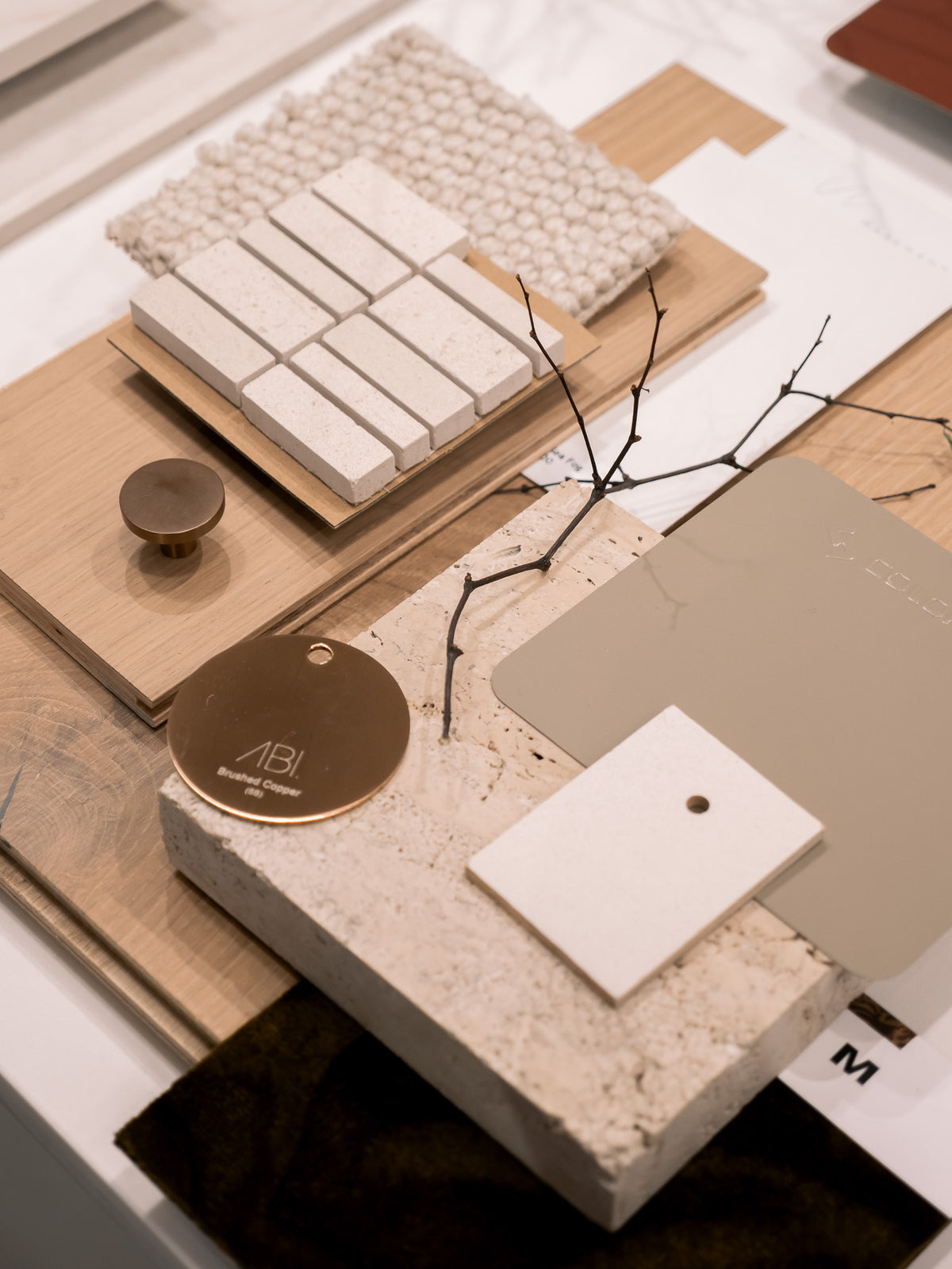 Smoke and Ash material flatlay in the Marchand studio: smoked grey European oak sample boards arranged with stone, tile and textile swatches for a muted colour scheme