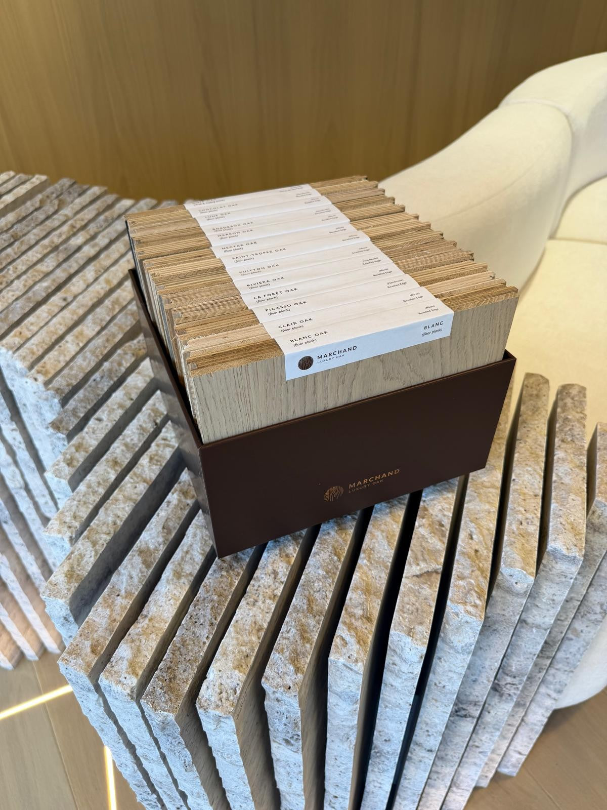 Marchand designer sample box holding the full European oak flooring collection, each board labelled by colour
